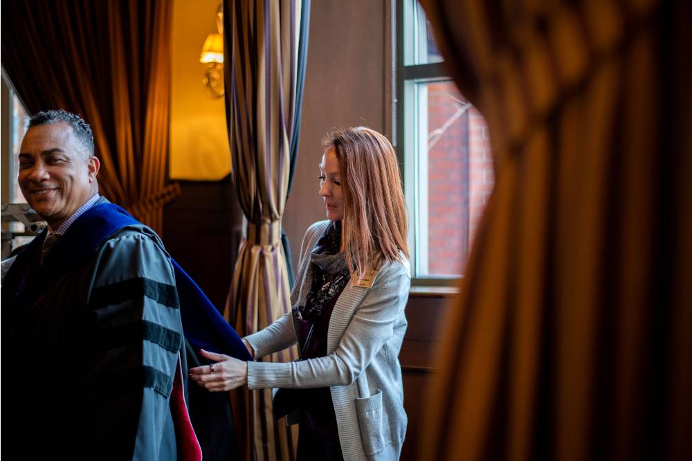 Woman adjusting faculty's uniform